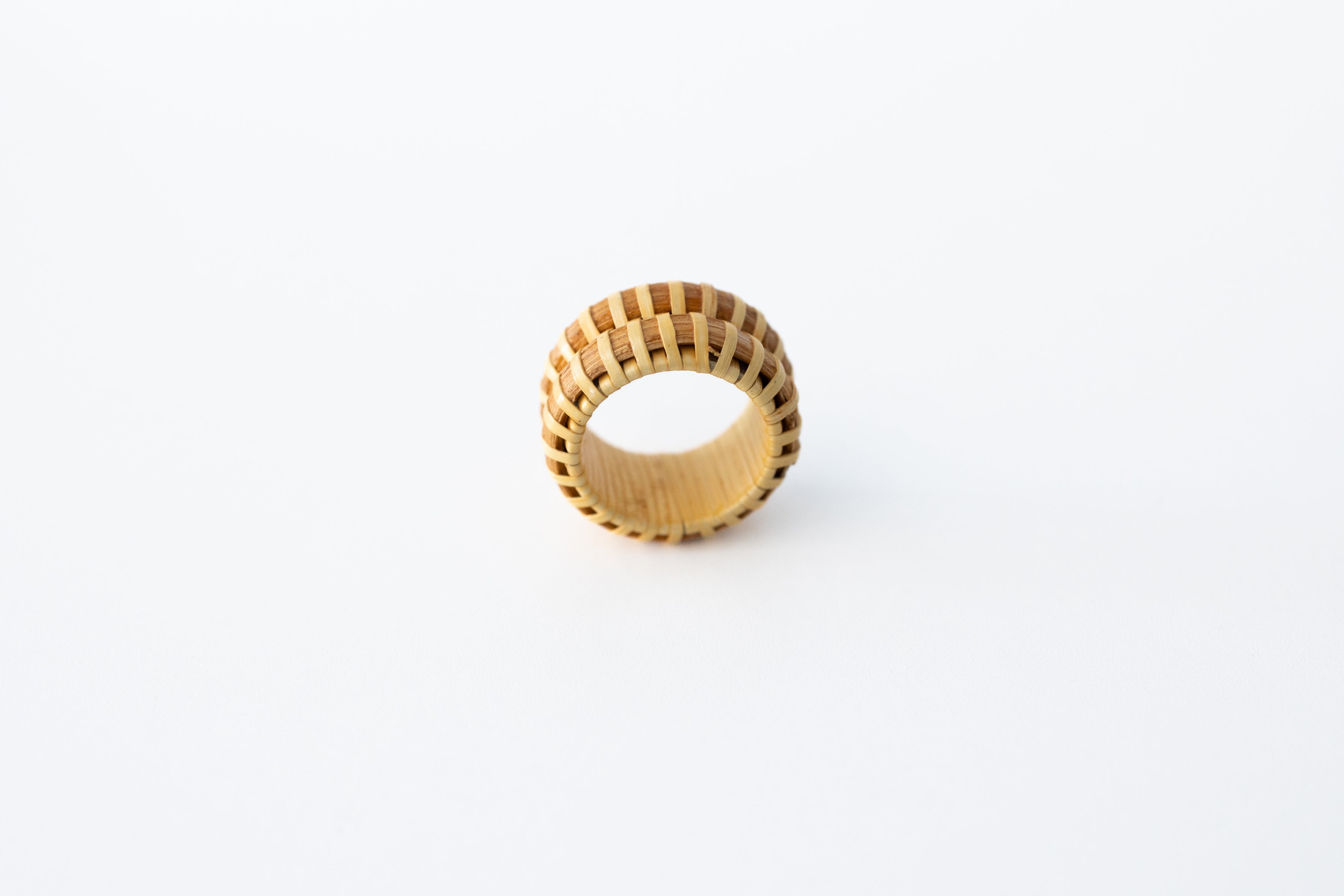A beige double stave Nantucket basket ring standing upright on a white background.