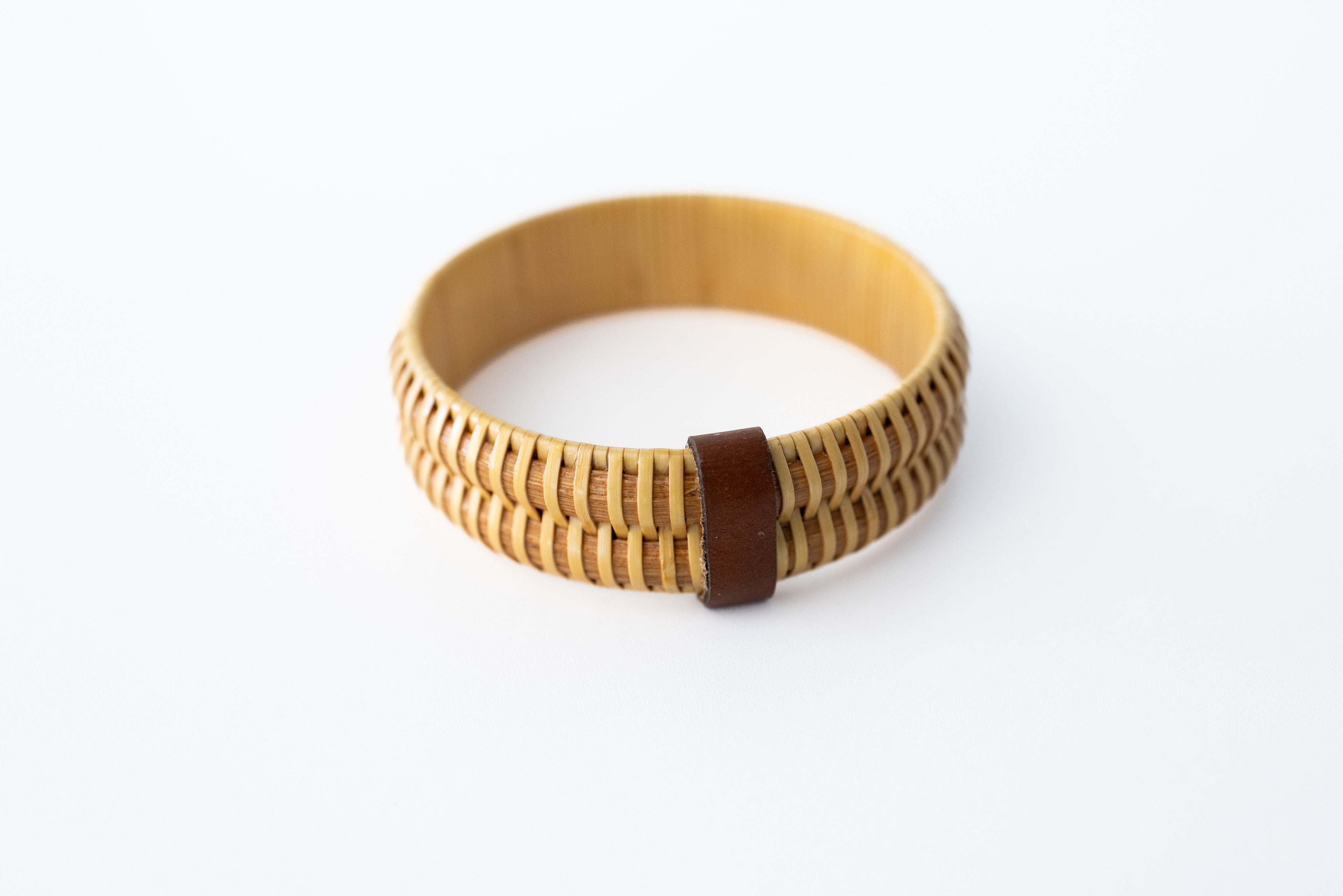 A beige-colored Nantucket basket bangle bracelet made of wood, displayed against a white background.