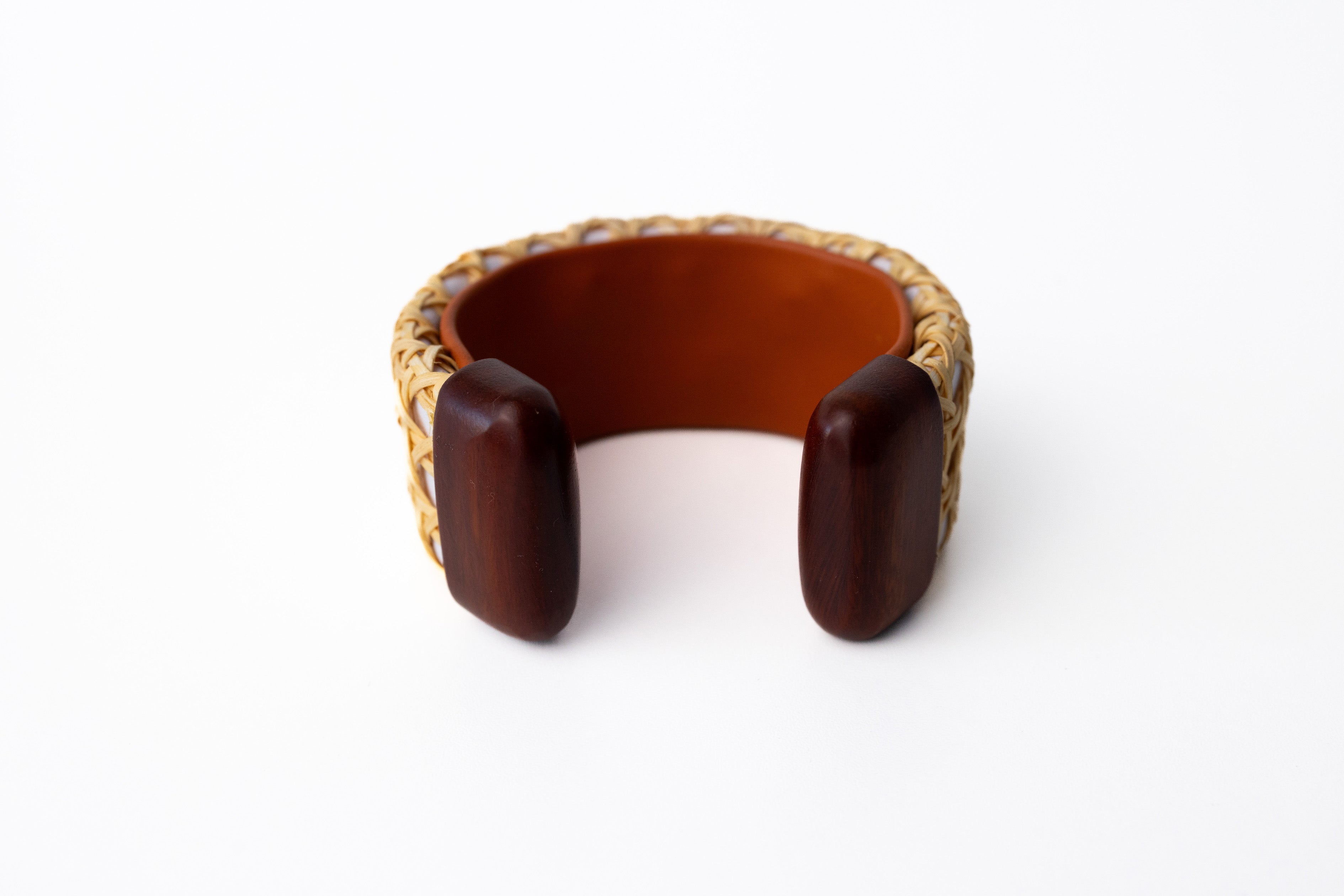 The inside of a white leather cuff bracelet with wooden ends.