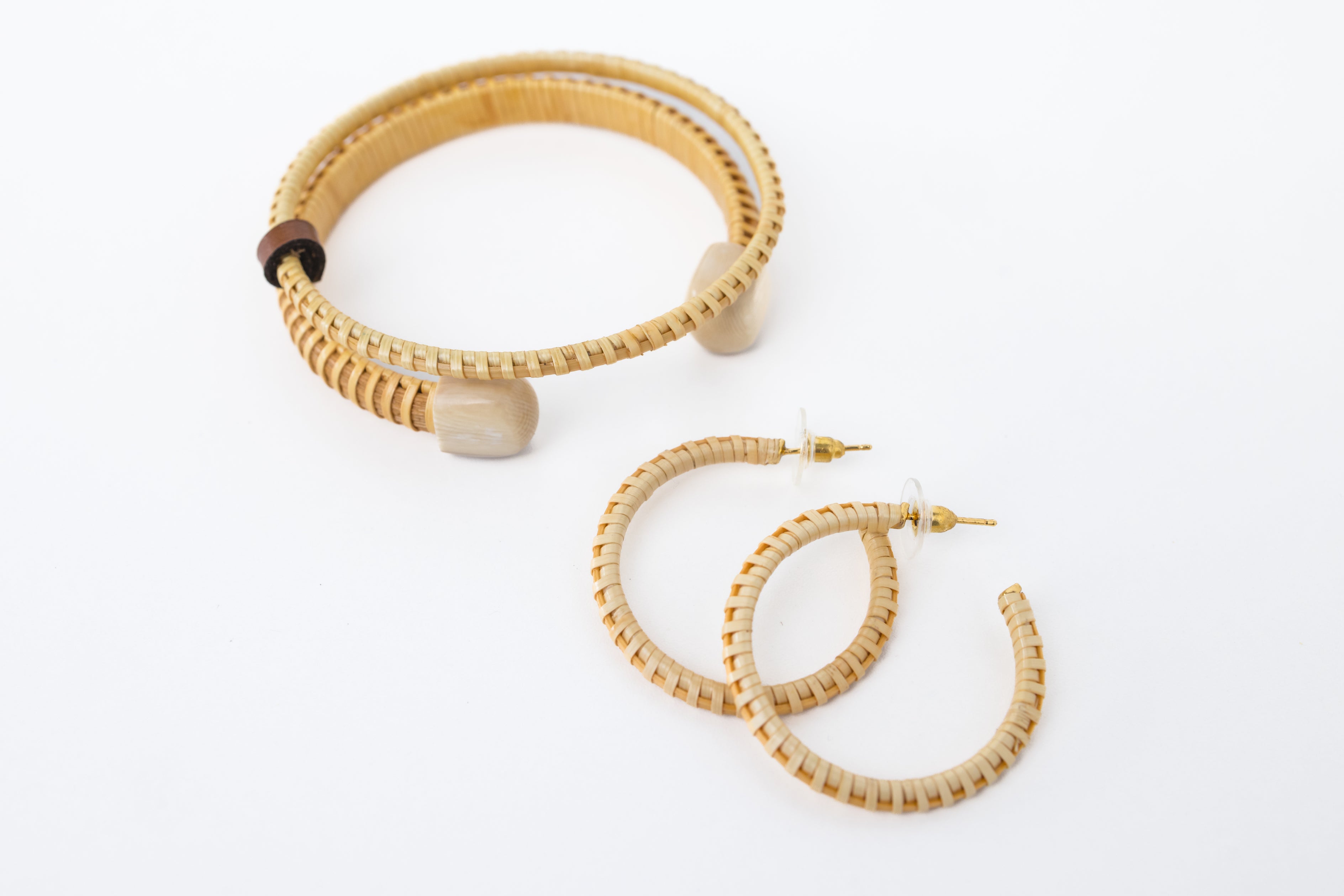 A set of jewelry including a beige Nantucket basket weave bracelet and matching earrings, with the bracelets displayed vertically and the earrings horizontally.