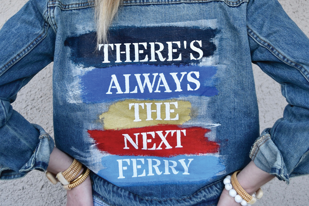 A denim jacket with the text 'There's Always The Next Ferry' painted on the back.