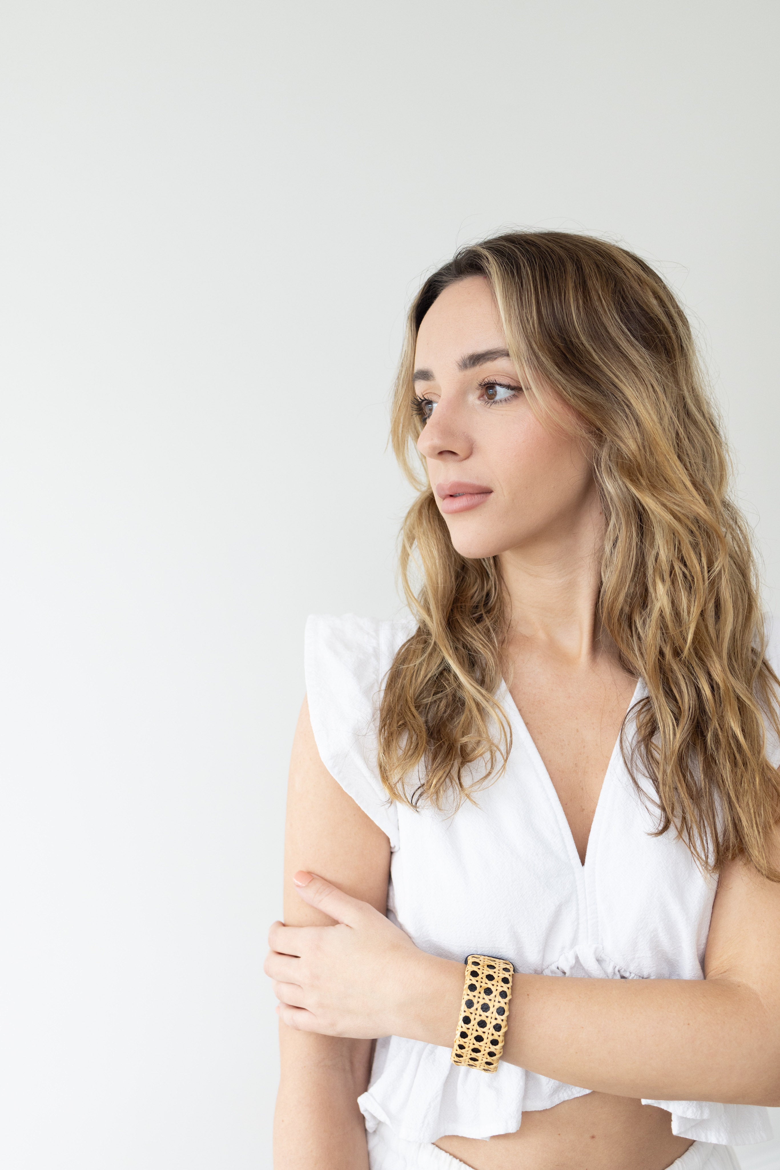 Woman in a white shirt with a black cuff around her wrist.