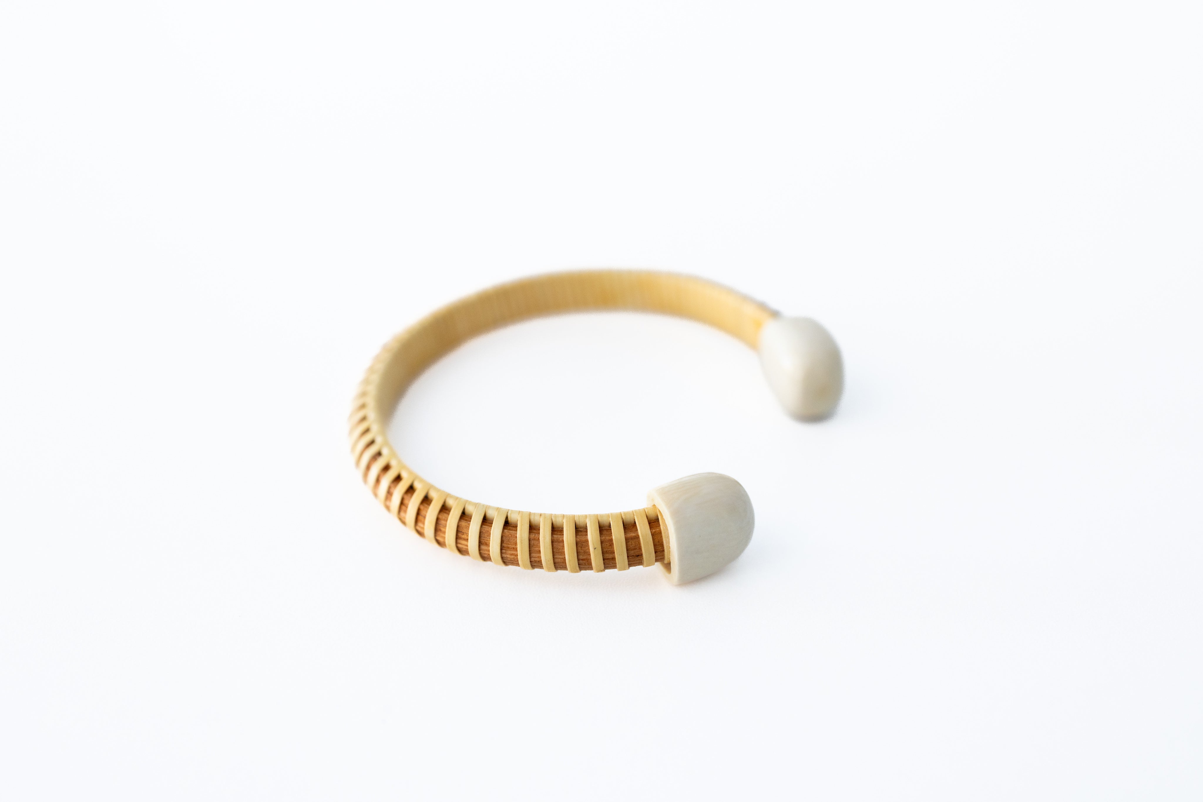A beige-colored Nantucket basket cuff bracelet with mammoth end caps, displayed on a white background.