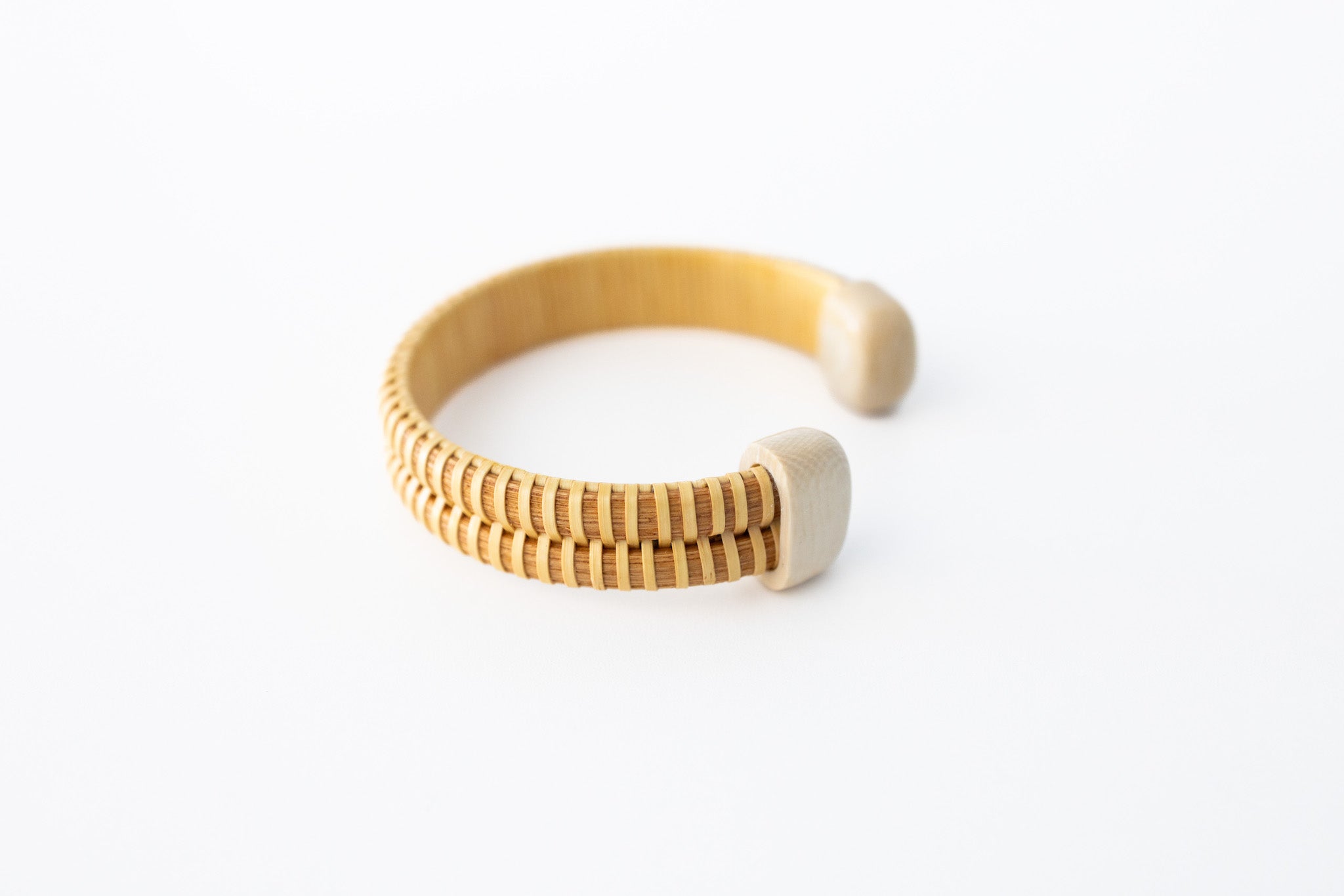 A double stave Nantucket basket cuff bracelet with mammoth end caps, displayed on a white background.