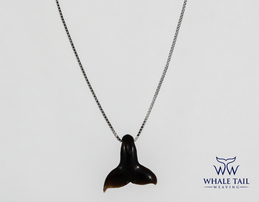 An ebony Nantucket Whale Tail Pendant on a silver chain, displayed against a white background.