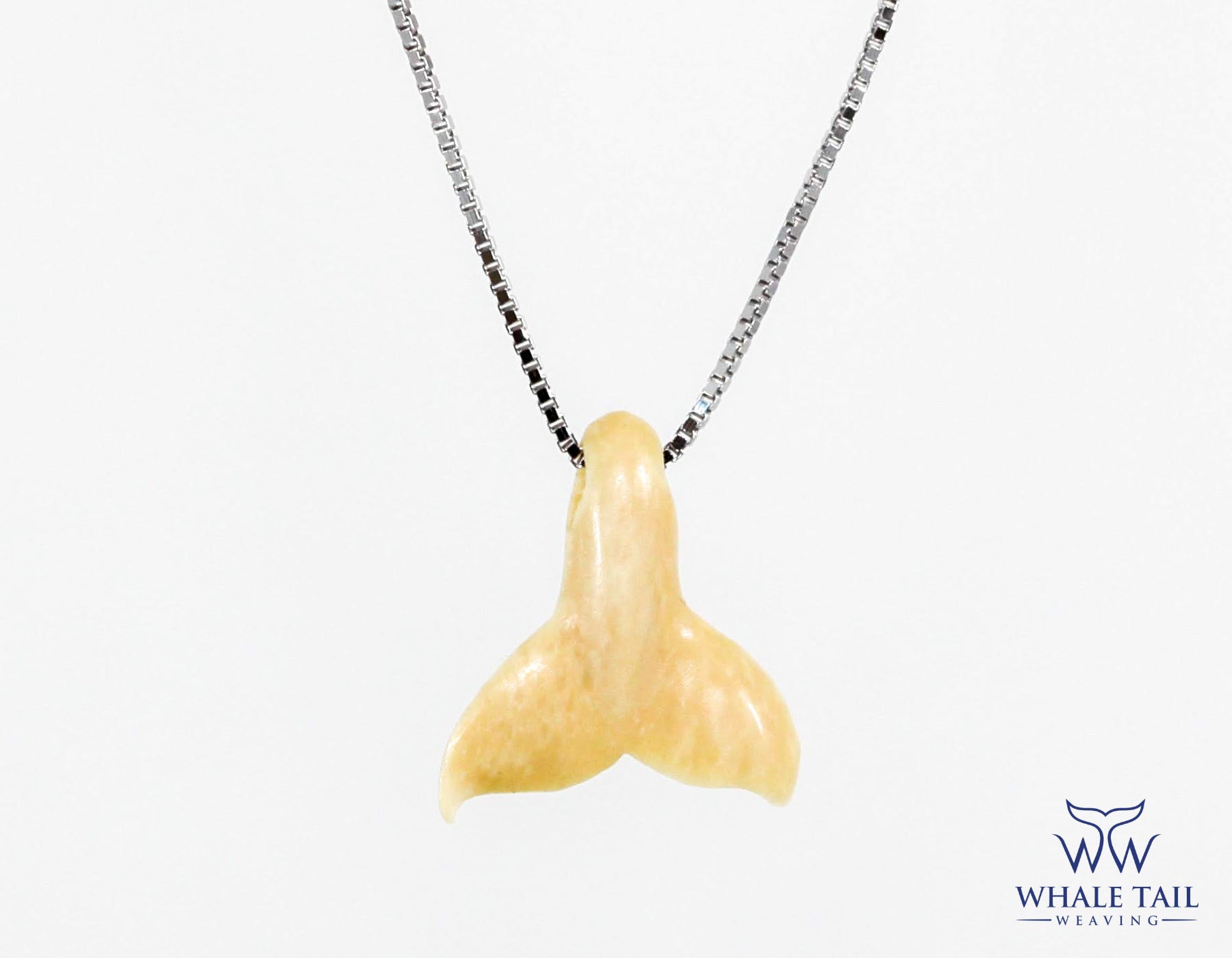 Close up of a Whale Tail Nantucket Pendant with a silver chain.