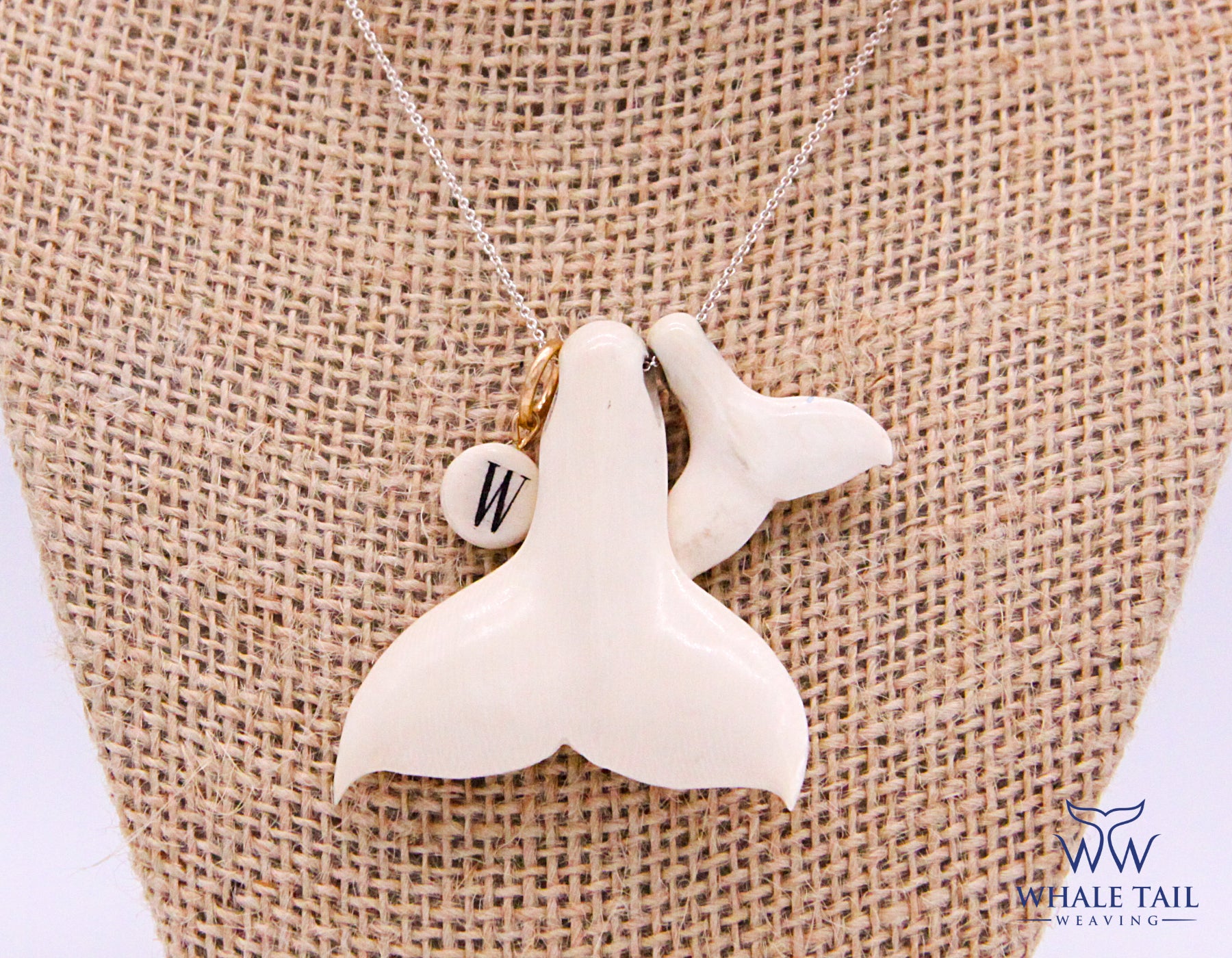 Two Nantucket Whale Tail Pendants side by side on a necklace.