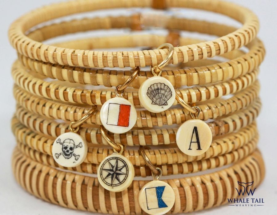 A stack of handcrafted bracelets with various nautical charms attached to each one.